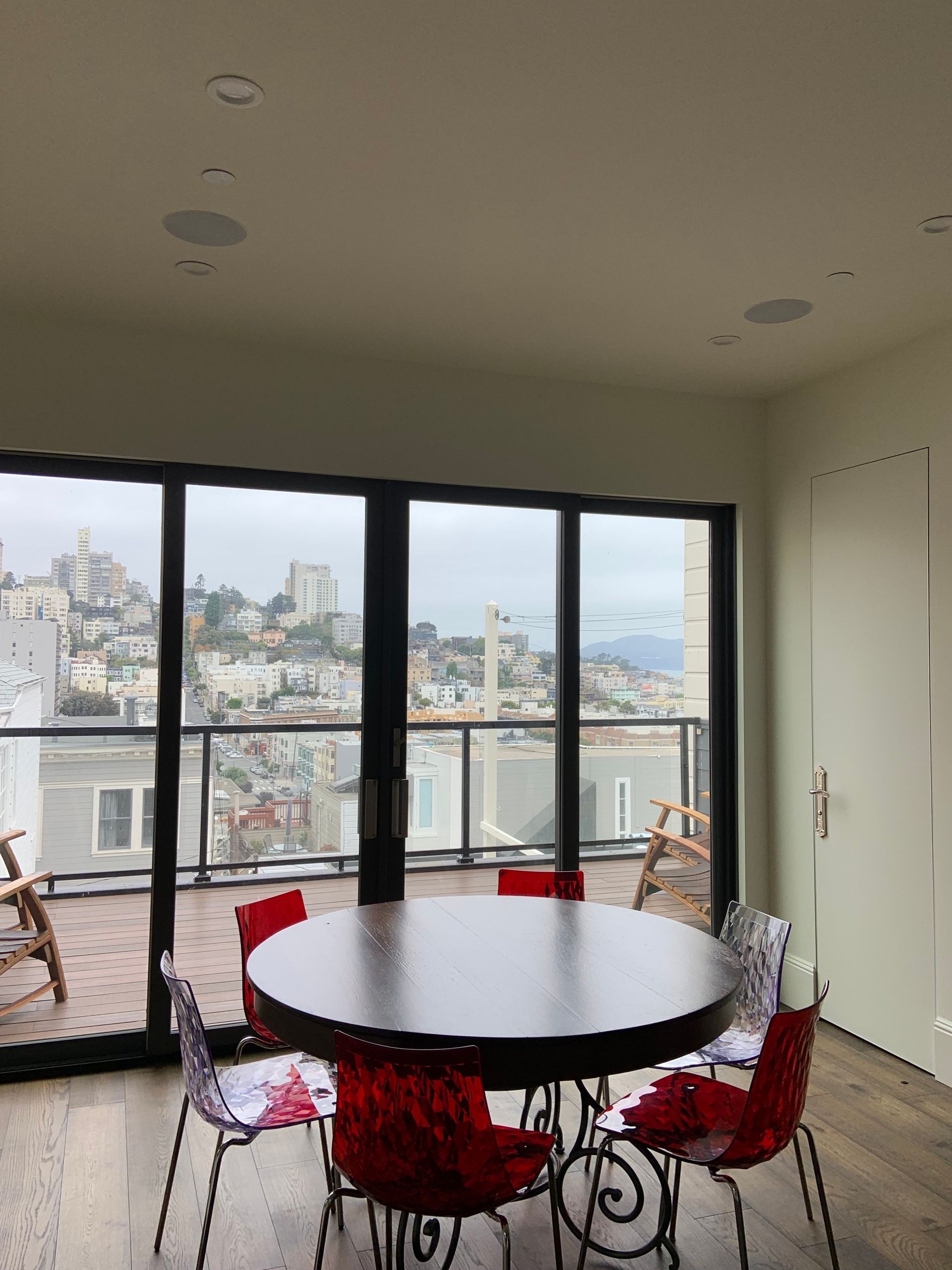 A dining room with a round table and red chairs
