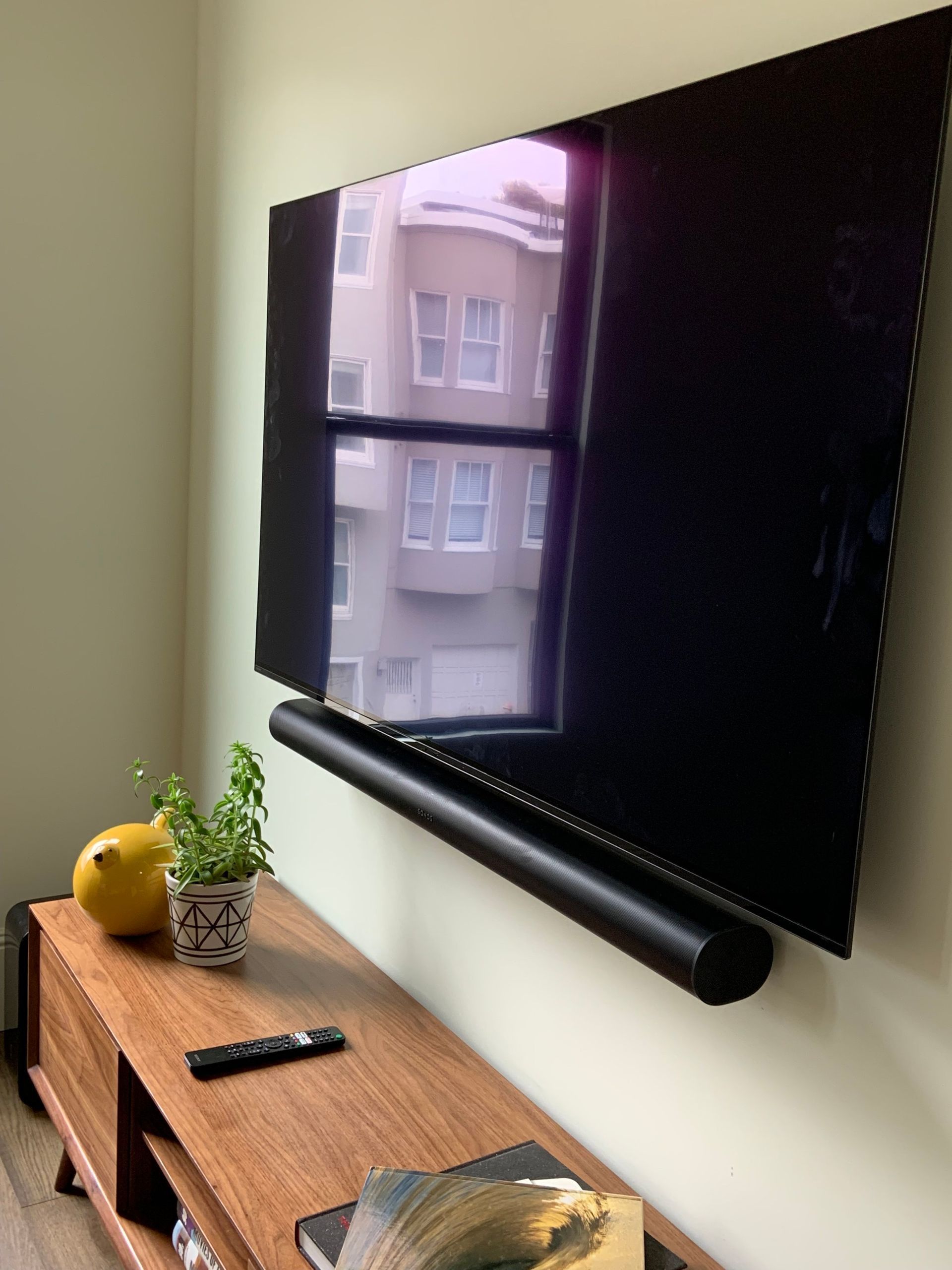A flat-screen tv is mounted on a wall above a wooden entertainment center