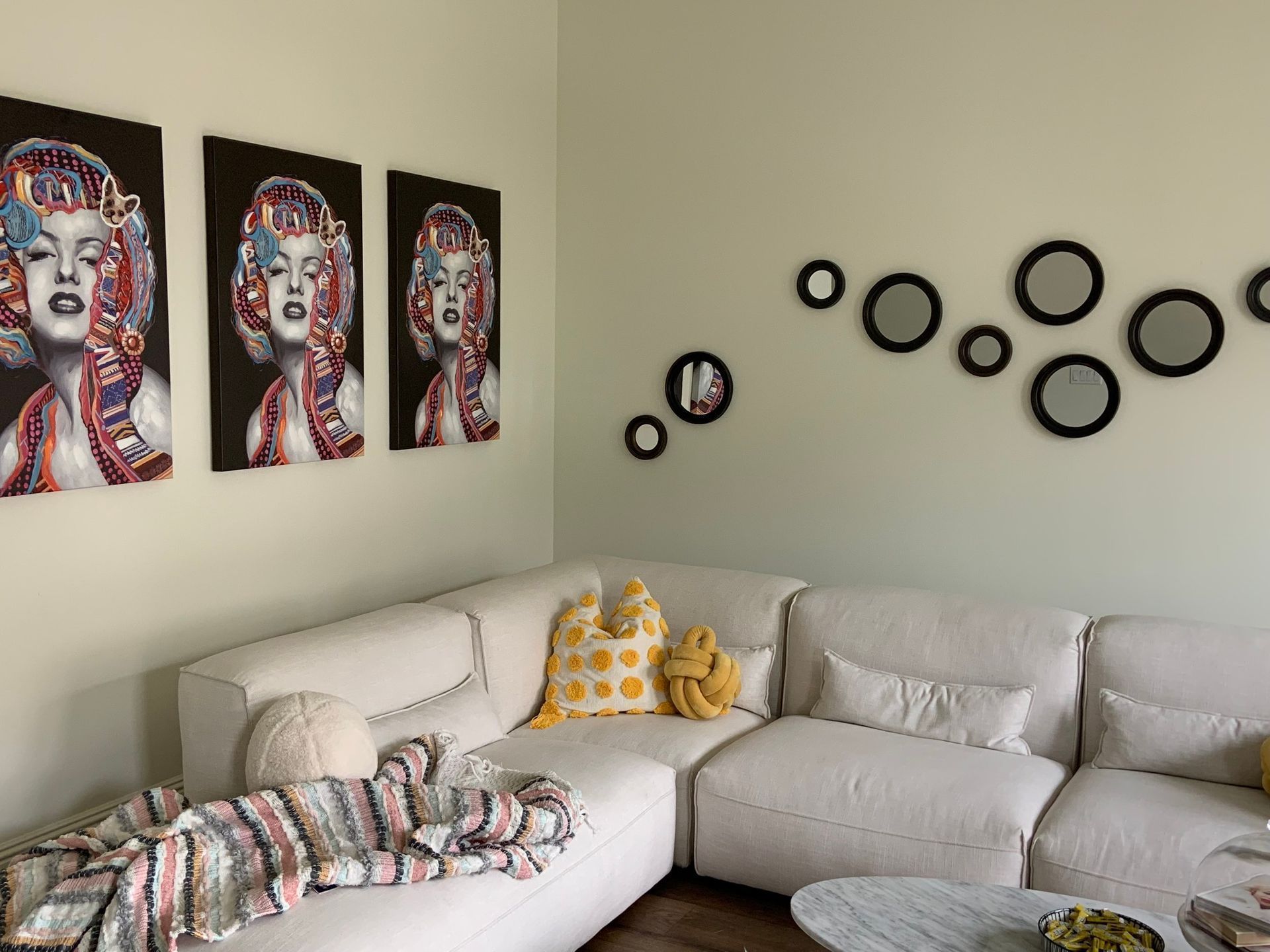 A living room with a couch and paintings on the wall