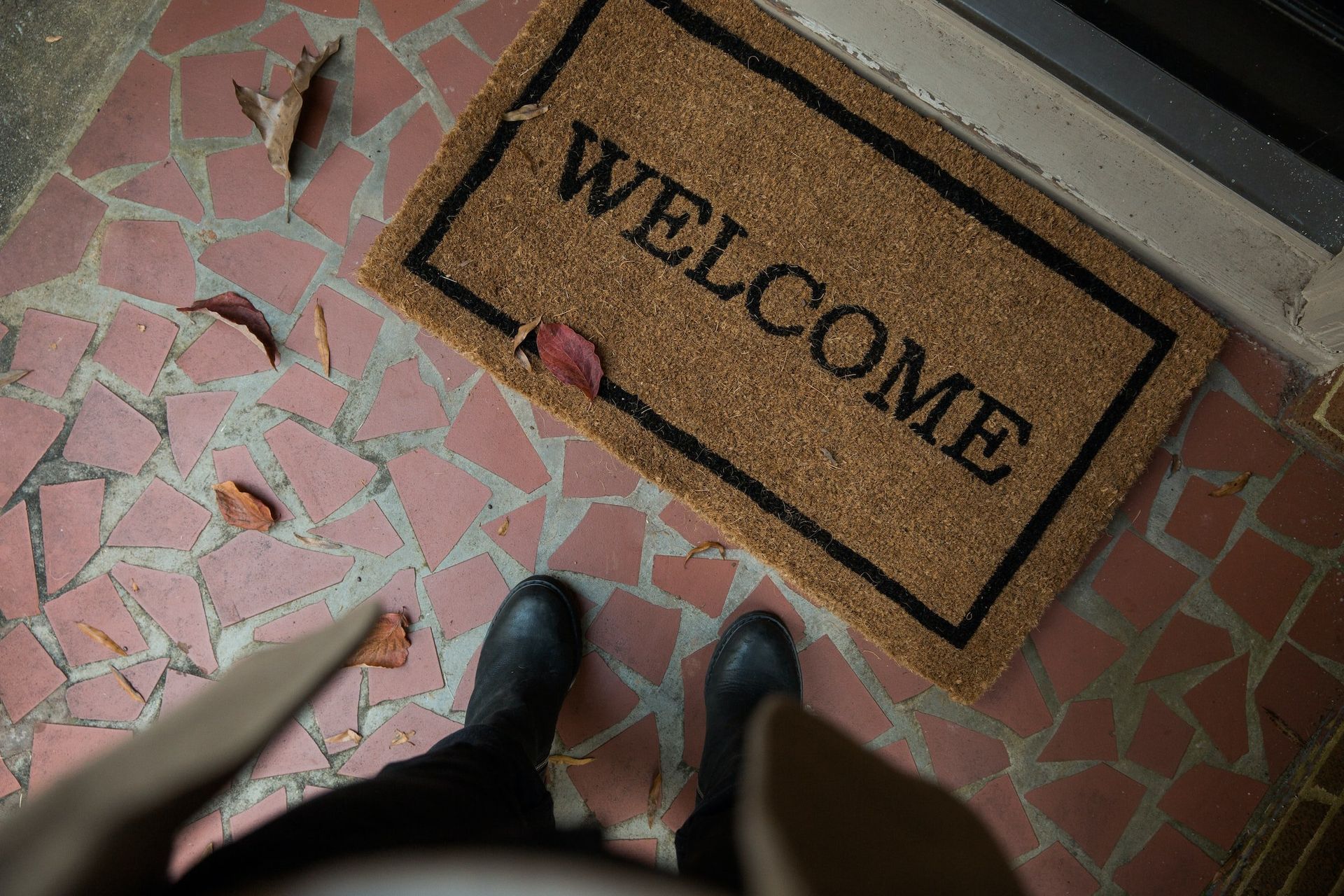 A person is standing in front of a welcome mat