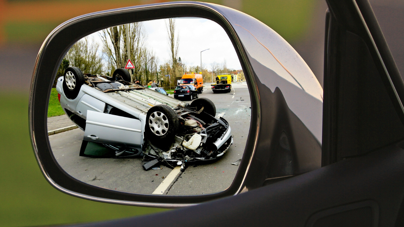A car accident is reflected in a rear view mirror