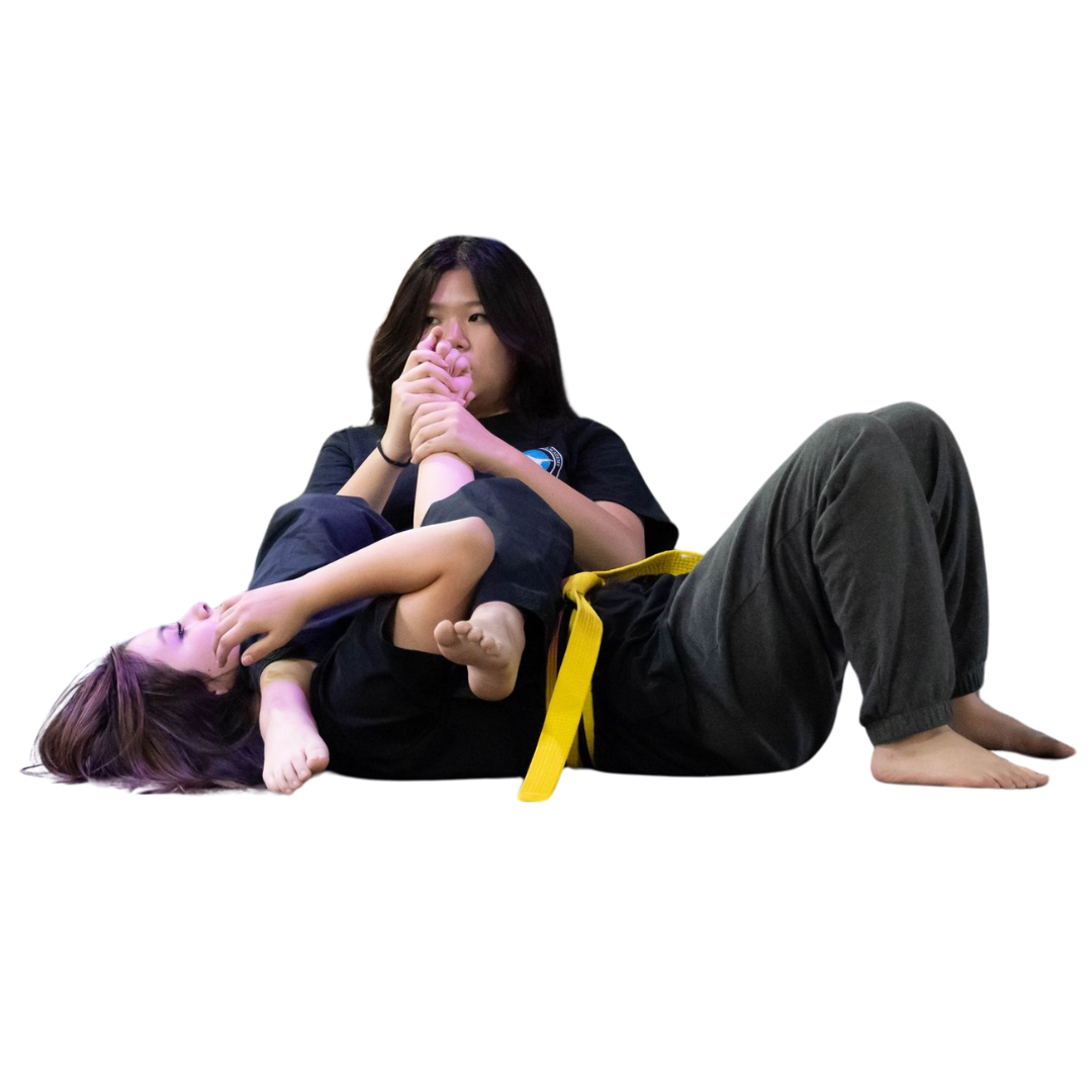 A boy and two girls are wearing karate uniforms and pointing at the camera