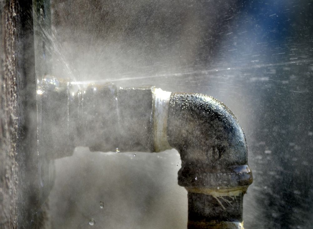 A Pipe Is Leaking Water And Steam Is Coming Out Of It — H2O Plumbing & Maintenance Services In Uralla, NSW