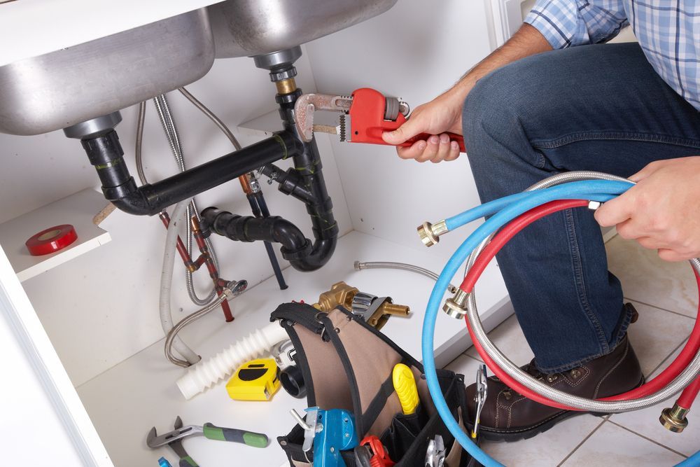 A Plumber Is Fixing A Sink With A Wrench — H2O Plumbing & Maintenance Services In Armidale, NSW