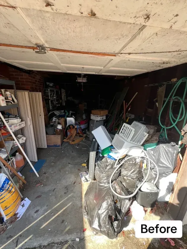 Cluttered garage before cleanup, filled with tools, cables, boxes, and debris