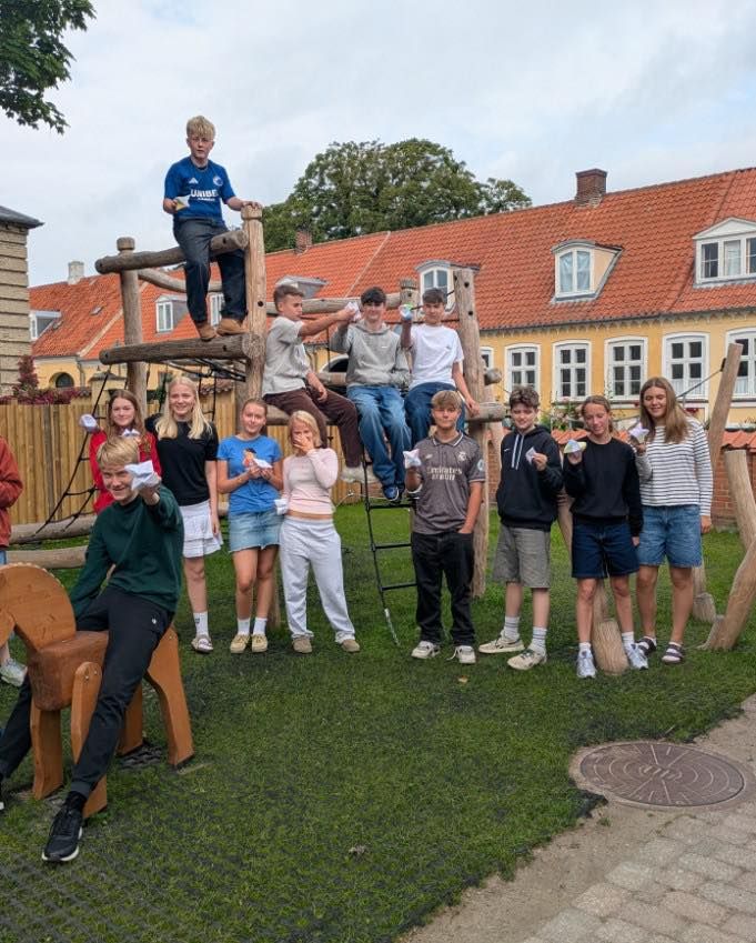 En gruppe unge mennesker poserer til et billede på en legeplads.