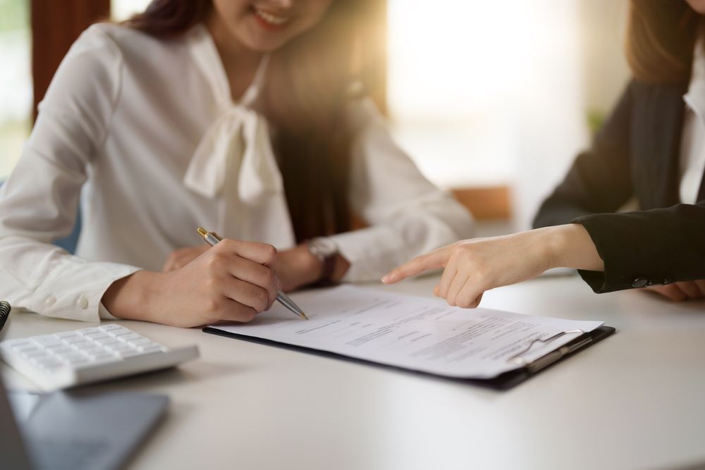 Two People At A Table With A Document — Pollock Ingram Solicitors in Caloundra, QLD