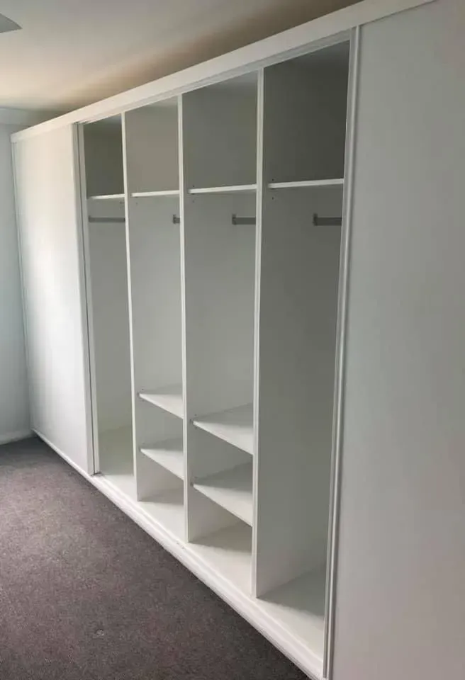 A Large White Wardrobe With Sliding Doors and Shelves in a Room — Moore Than Just Kitchens In Manilla, NSW