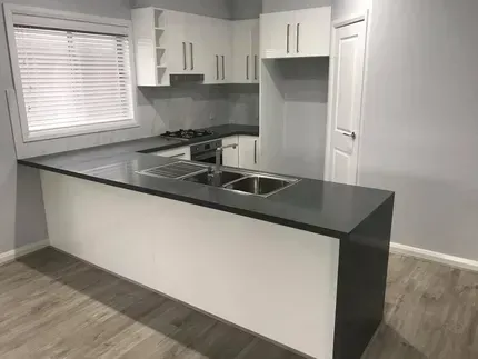 A Kitchen With White Cabinets and a Black Counter Top — Moore Than Just Kitchens In Manilla, NSW