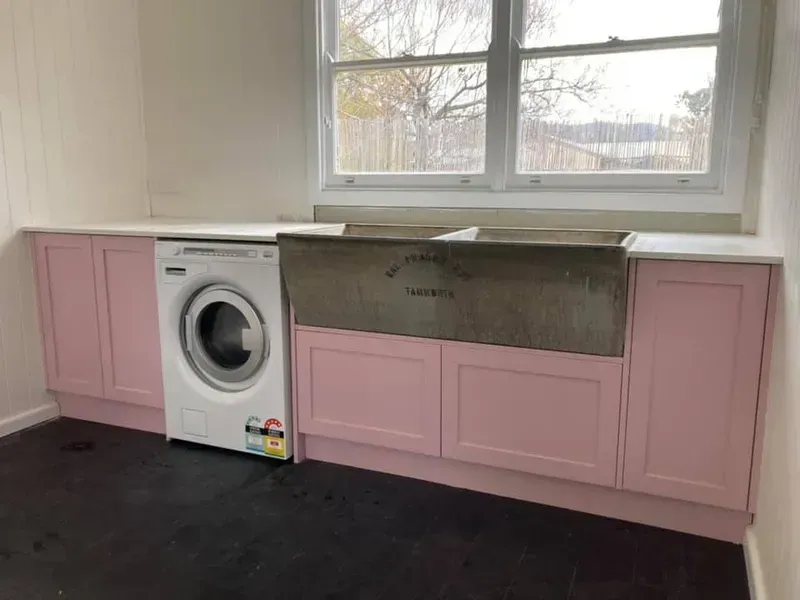 A Laundry Room With Pink Cabinets, a Washer and Dryer, and a Sink — Moore Than Just Kitchens In Manilla, NSW