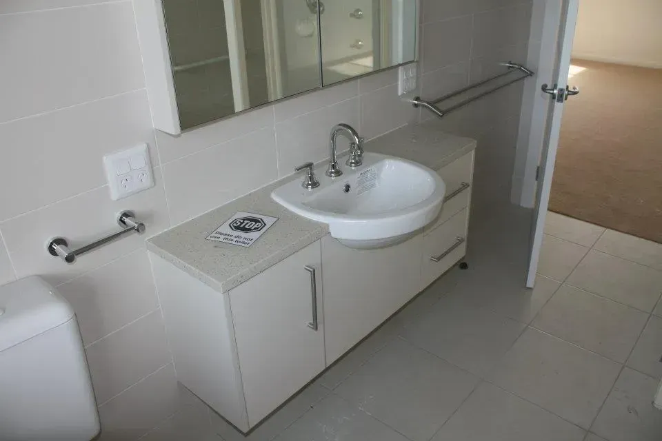 A Bathroom With a Sink, Toilet and Mirror — Moore Than Just Kitchens In Manilla, NSW