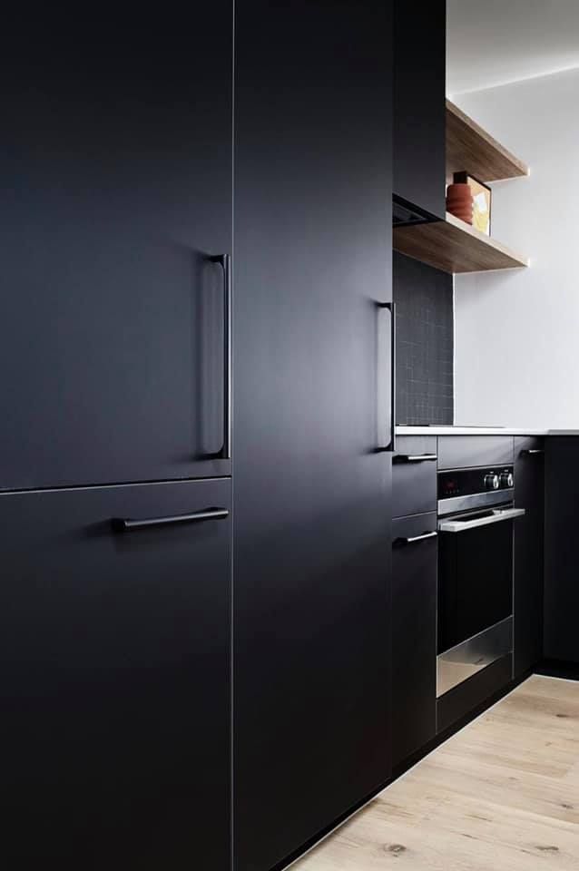 A Kitchen With Black Cabinets and a Wooden Floor — Moore Than Just Kitchens In Wee Waa, NSW
