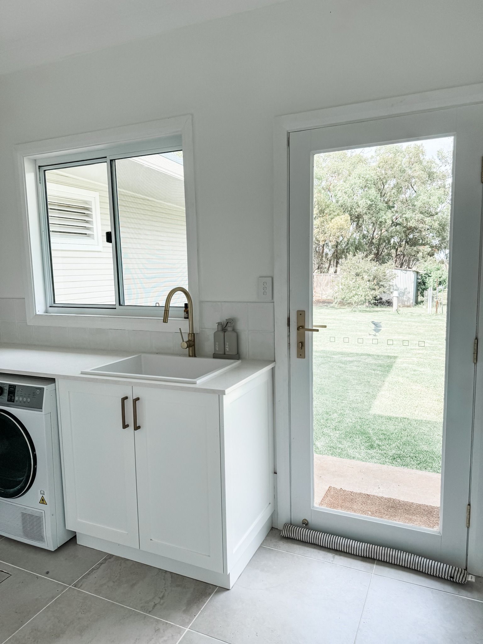 A Laundry Room With a Washer and Dryer, Sink, and Window — Moore Than Just Kitchens In Manilla, NSW
