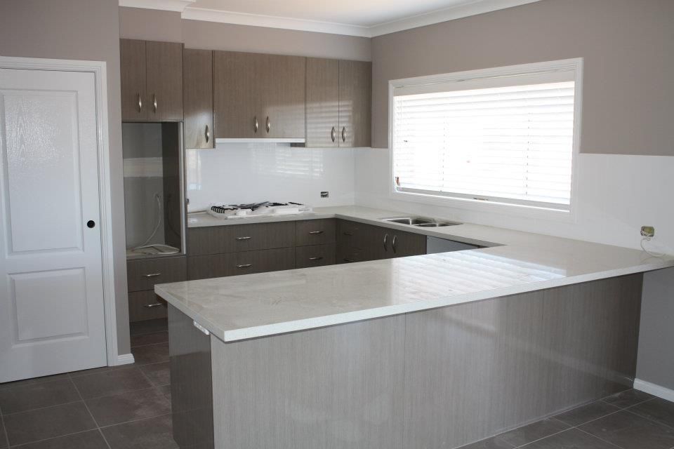 An Empty Kitchen With a Large Island and a Window — Moore Than Just Kitchens In Tamworth, NSW