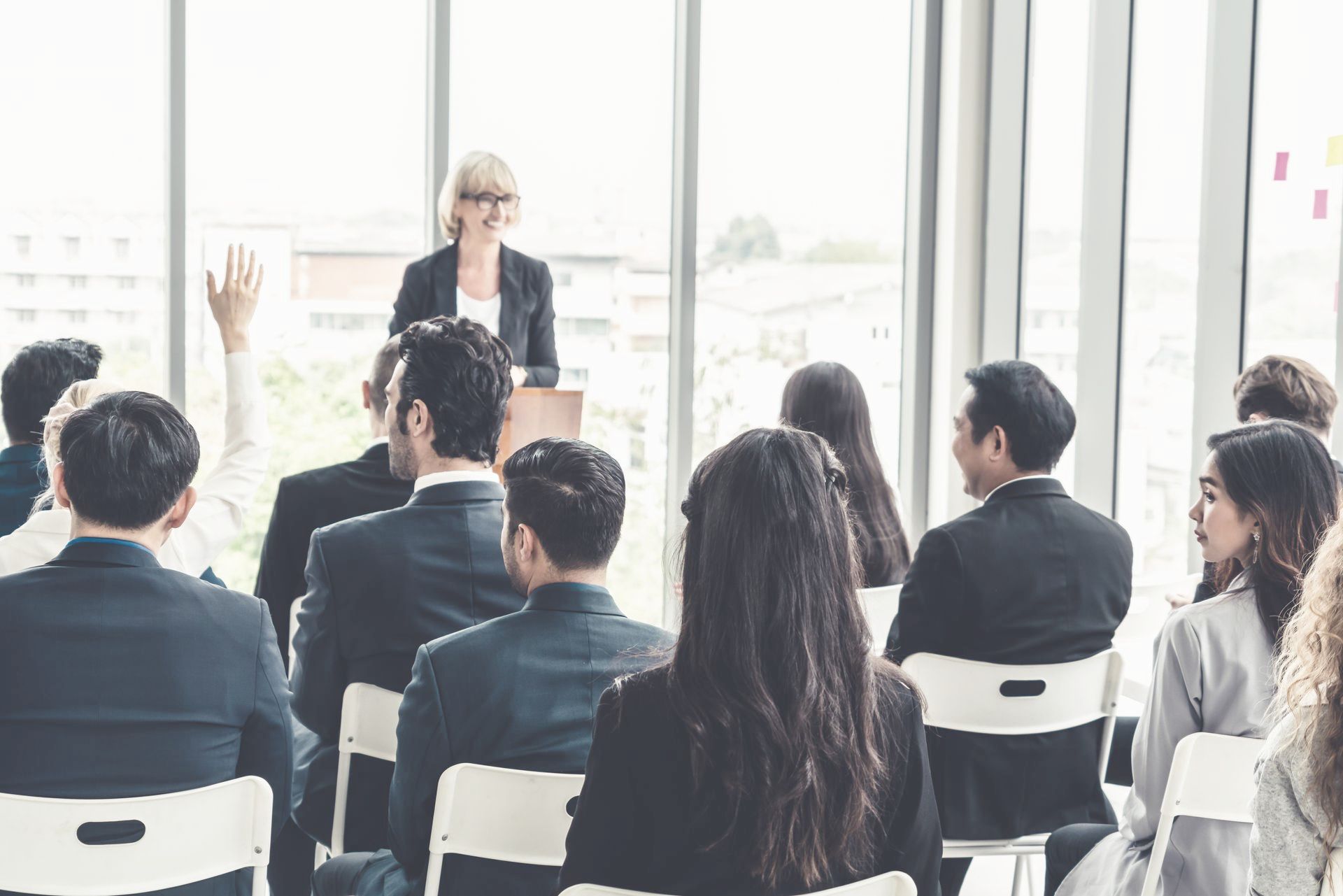 A woman is giving a presentation to a group of people in a conference room.