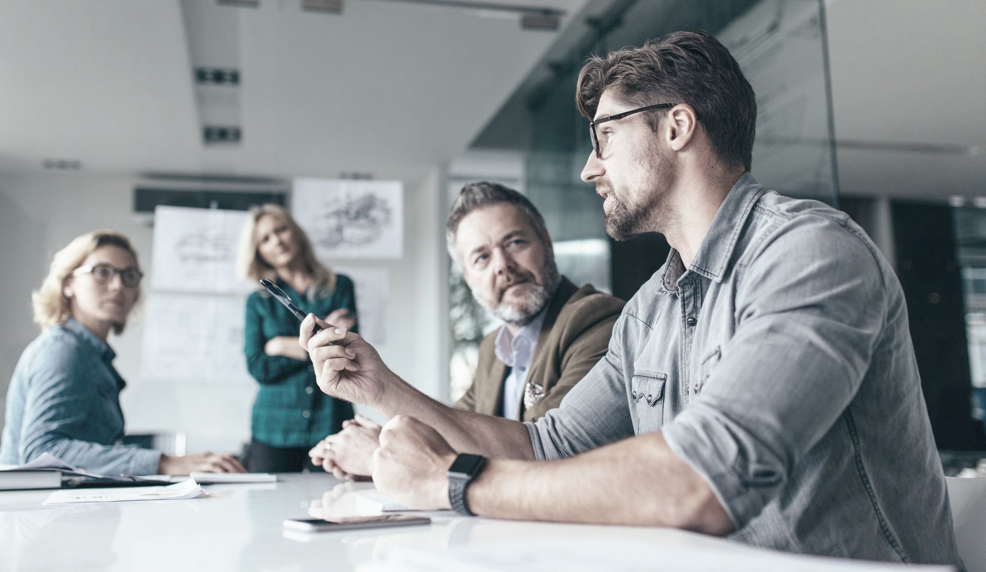A group of people are sitting around a table having a meeting.