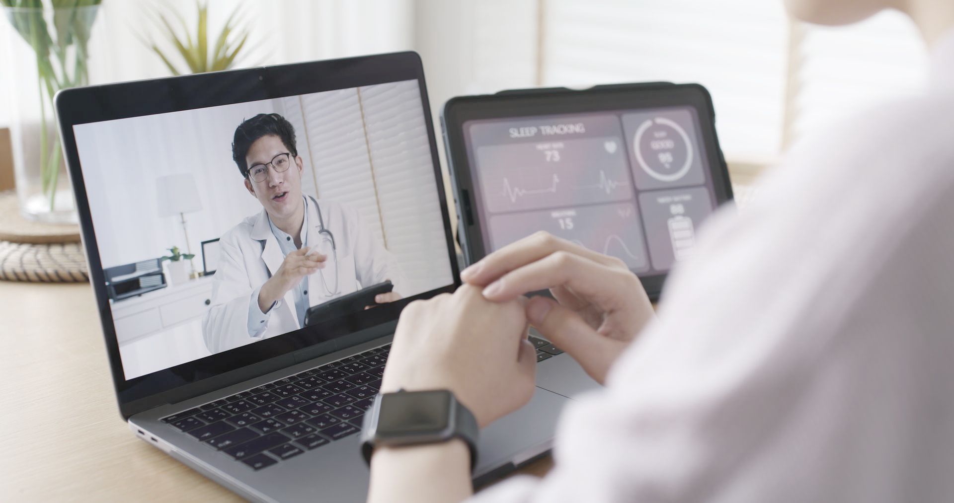A woman is having a video call with a doctor on her laptop.
