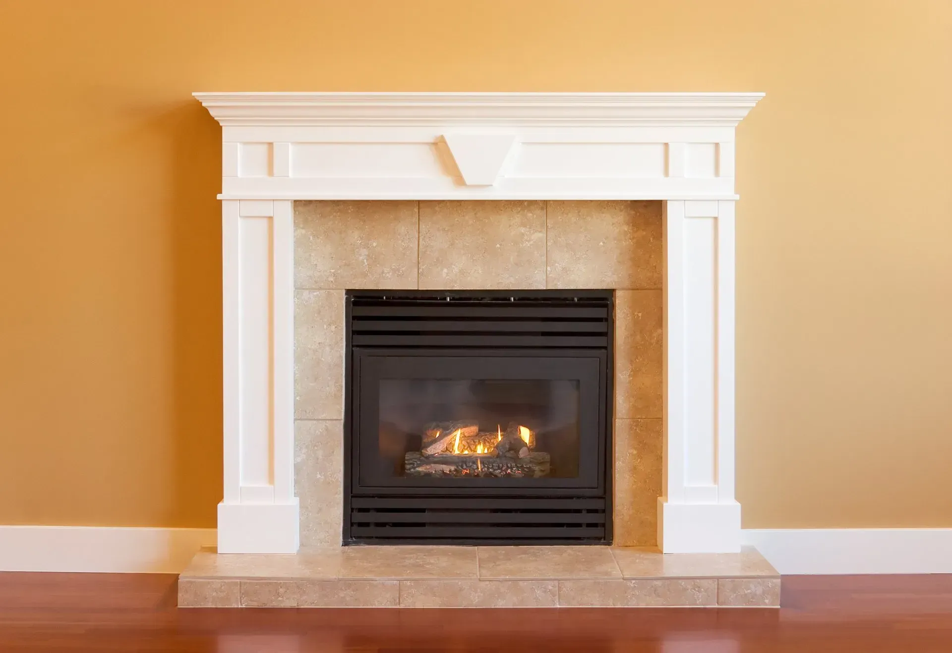 A fireplace with a white mantle in a living room.