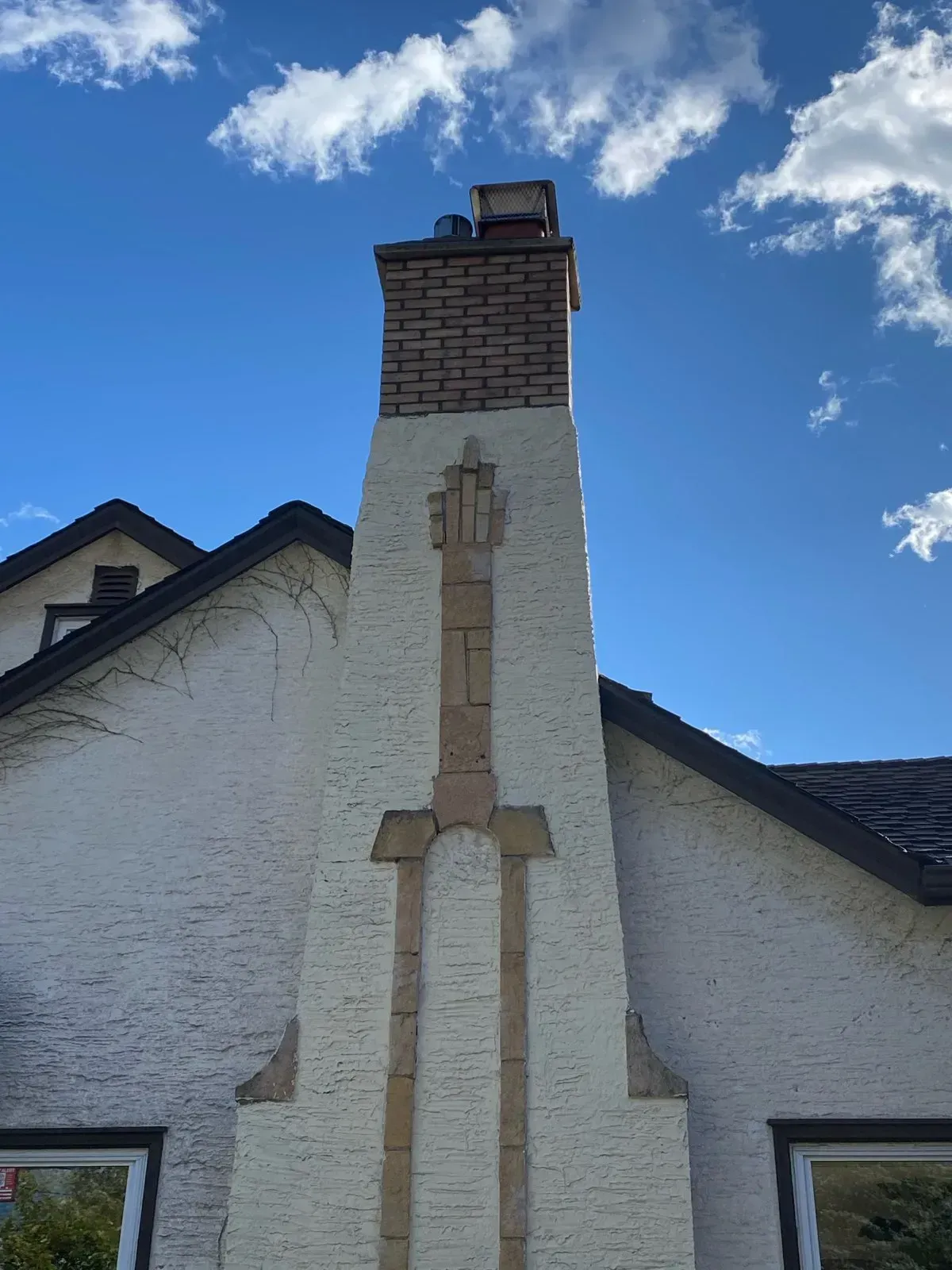 A chimney on the side of a building with a blue sky in the background
