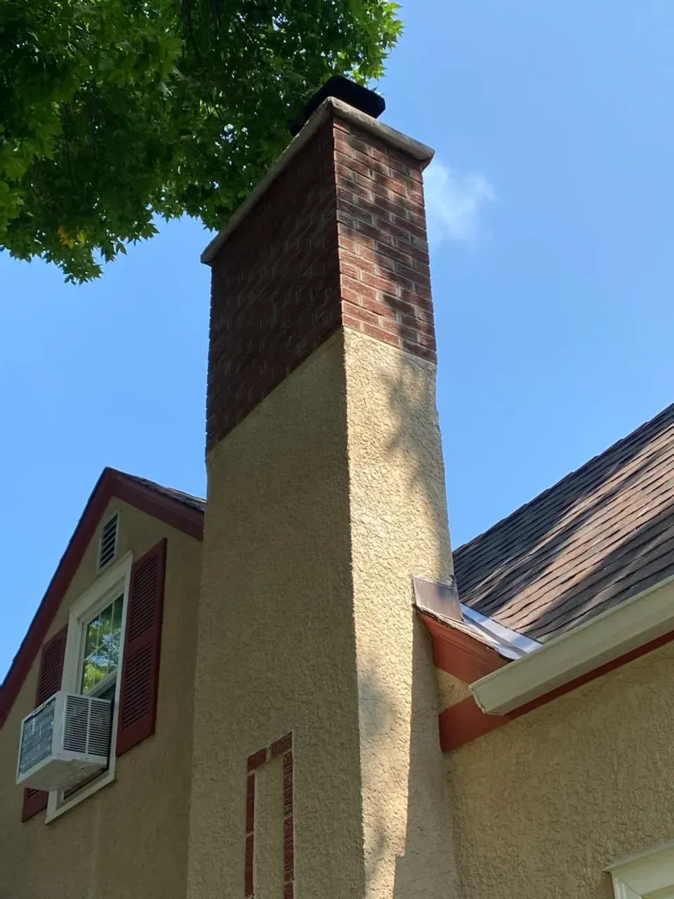 A brick chimney on the side of a house