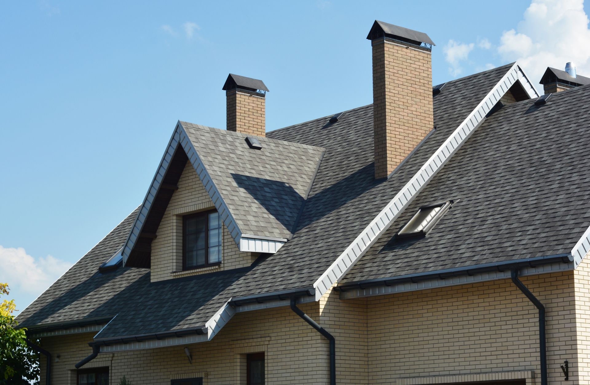Contemporary home with tall chimneys and complex gable rooflines.