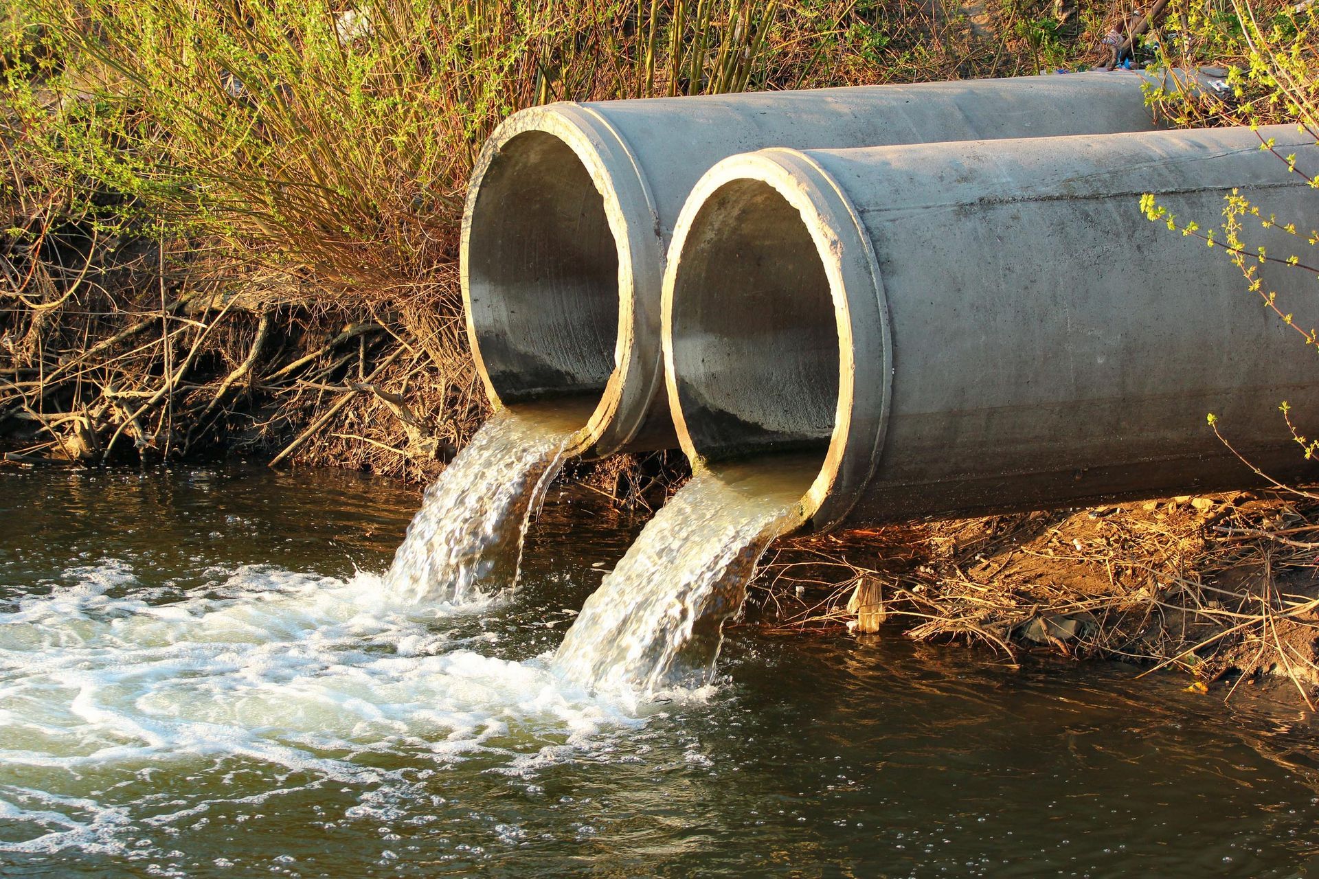 Pipes Pouring Water Into A River — Hawthorne, NY — Better Home Sewage Services, Inc.