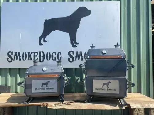 Two smokedogs are sitting on a wooden table in front of a sign.