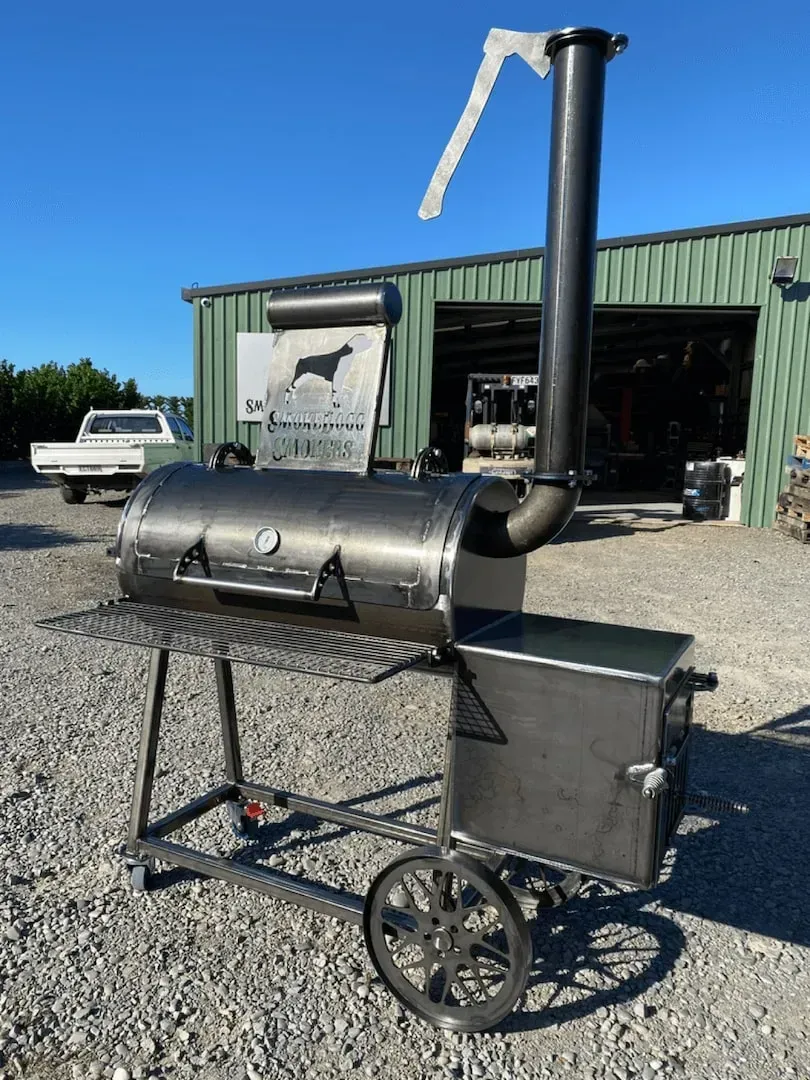 A large bbq grill is sitting in front of a building.