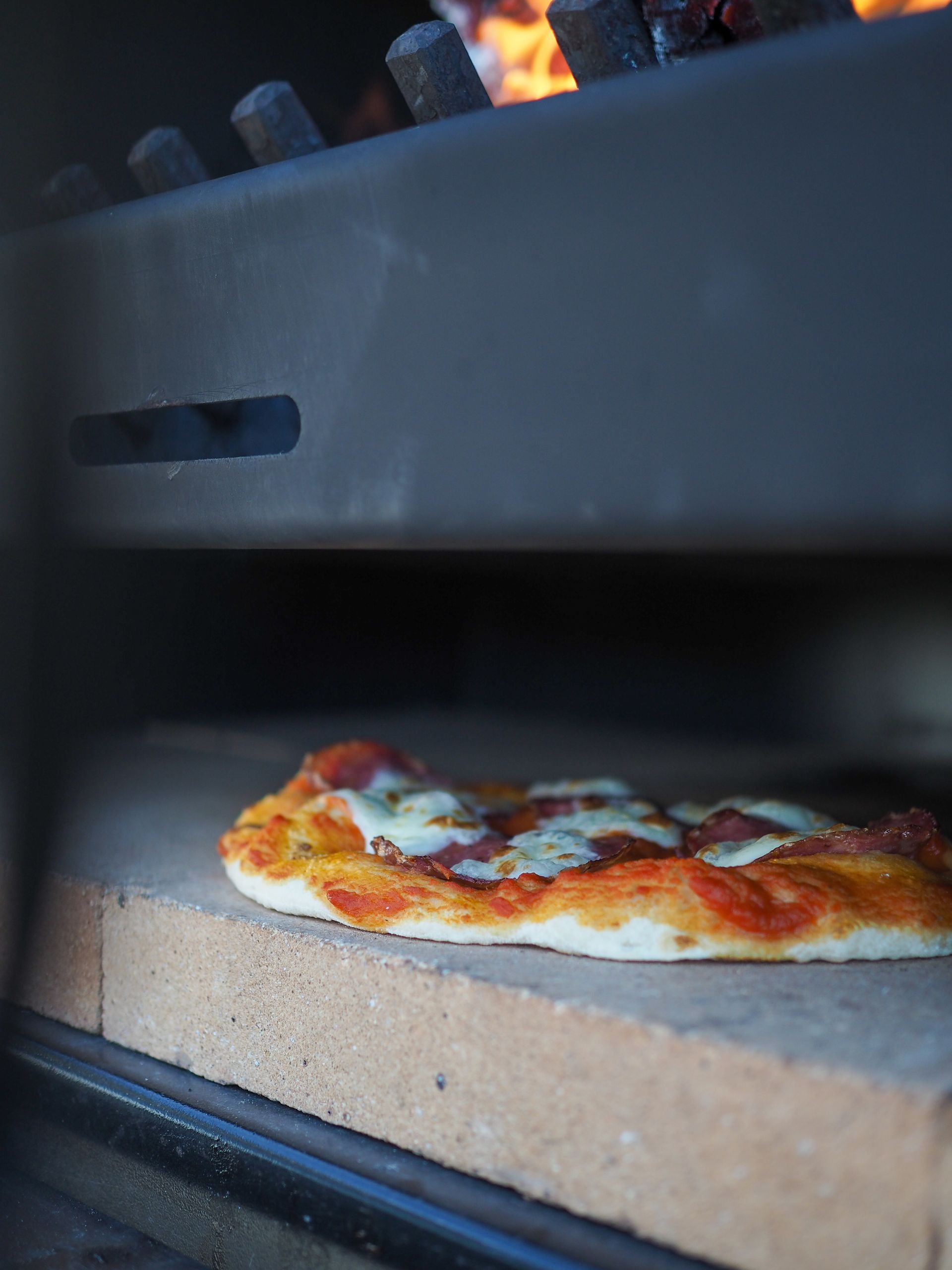 A pizza is being cooked in a brick oven