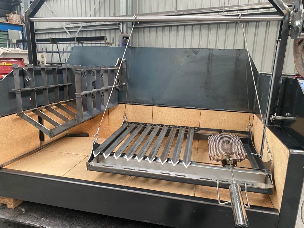 A metal grill is sitting on top of a wooden table.