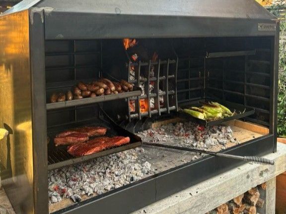 A grill with meat and vegetables cooking on it.