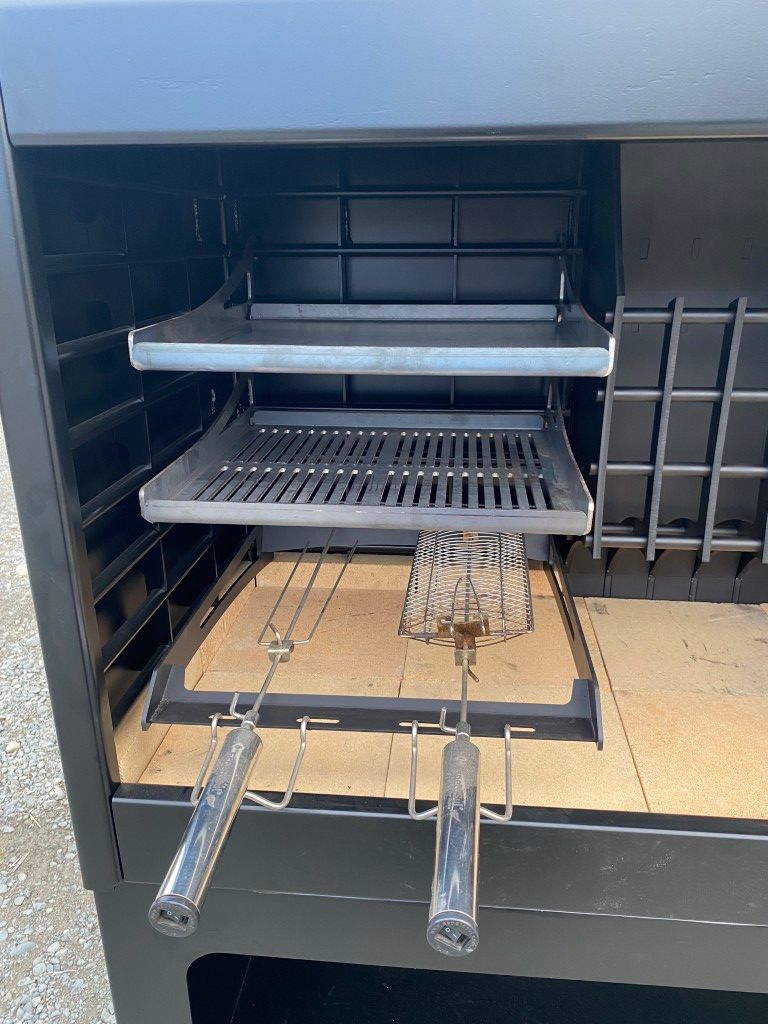 The inside of a grill with three shelves and two grills.
