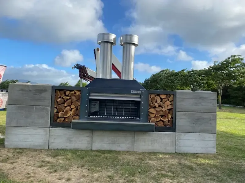 A large fireplace with a bunch of logs in front of it.