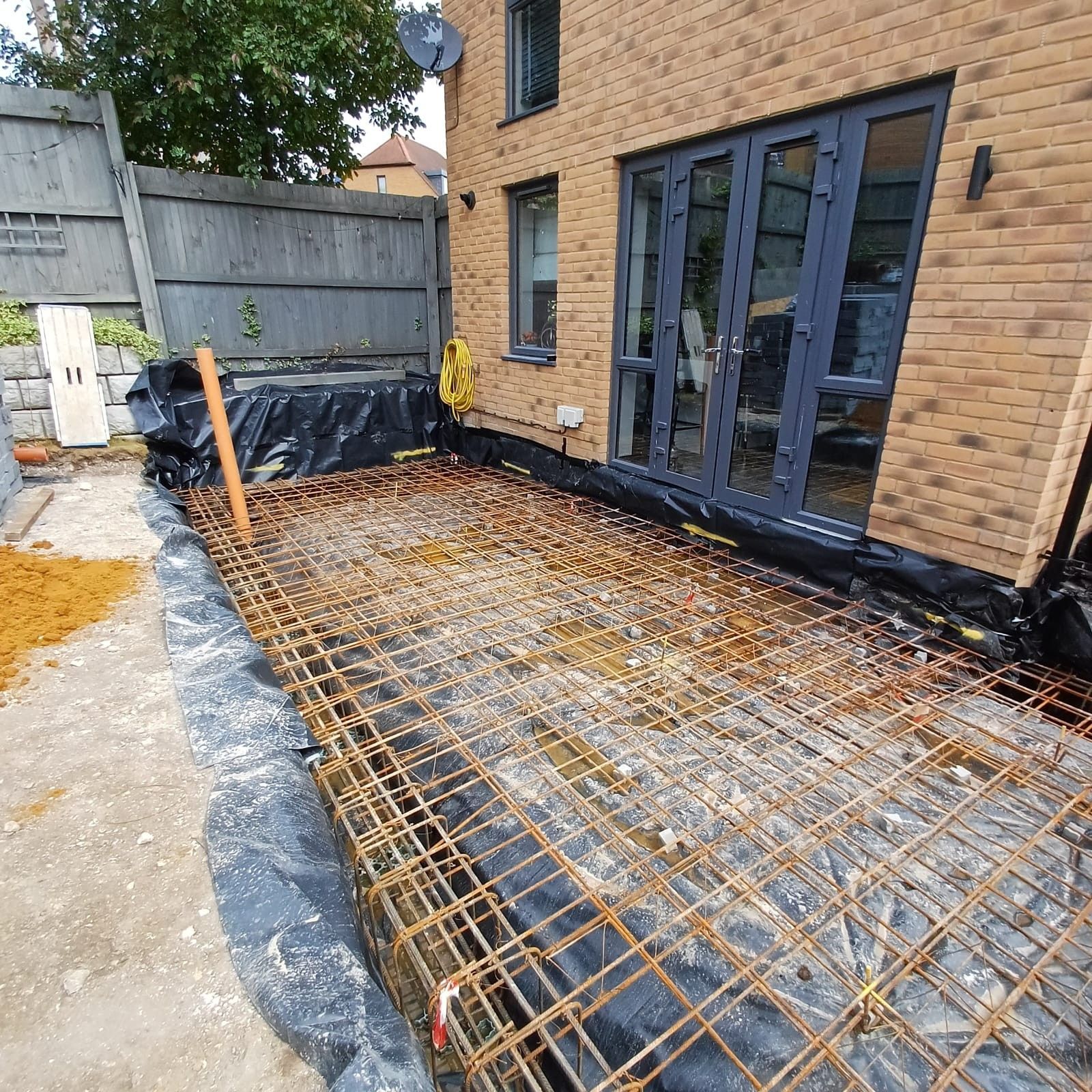 Reinforced concrete slab and steel mesh groundworks for house extension, South London