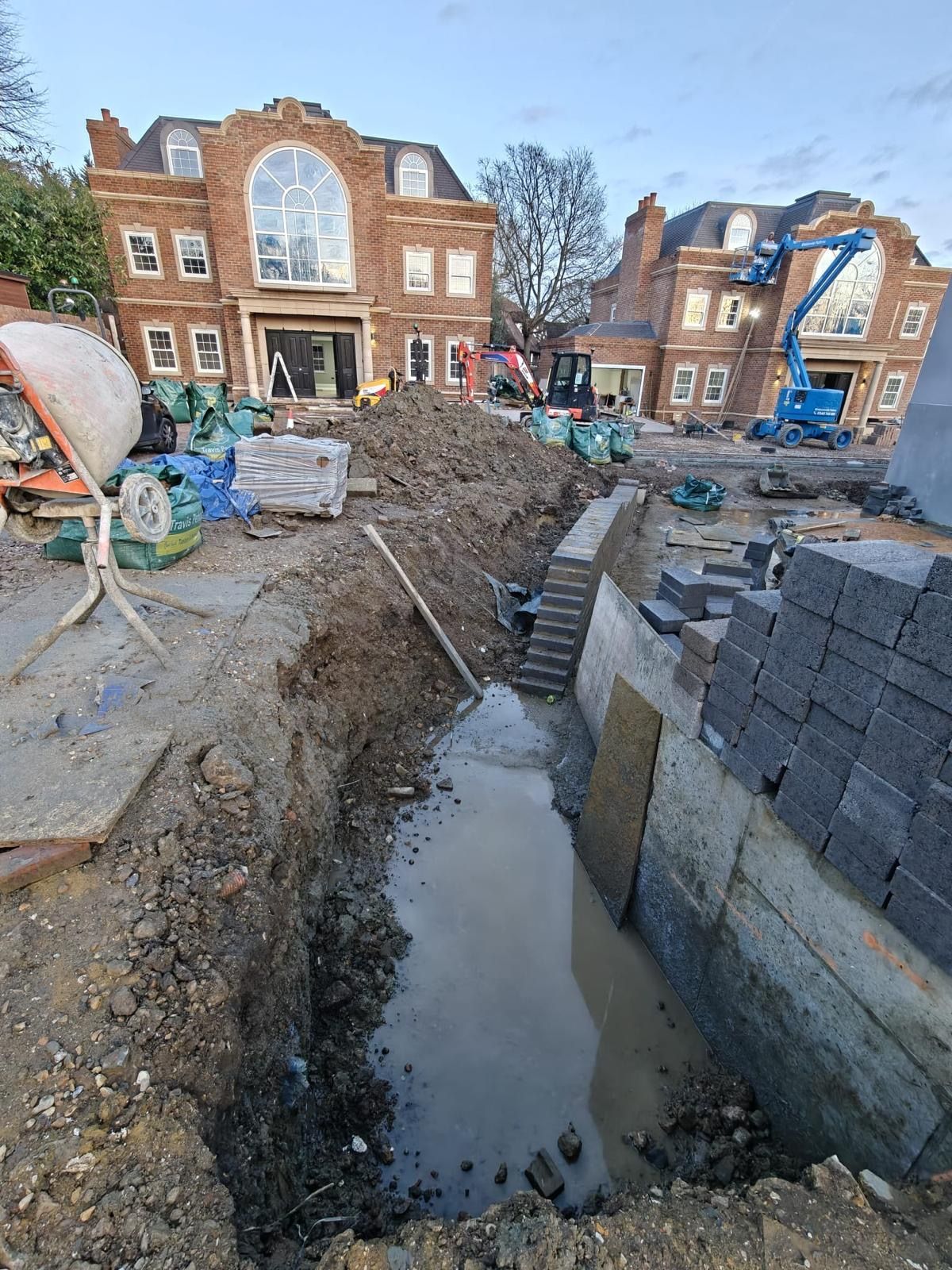 Active construction site at Sylvanias Cottages, New Malden, showing crane and building works in progress