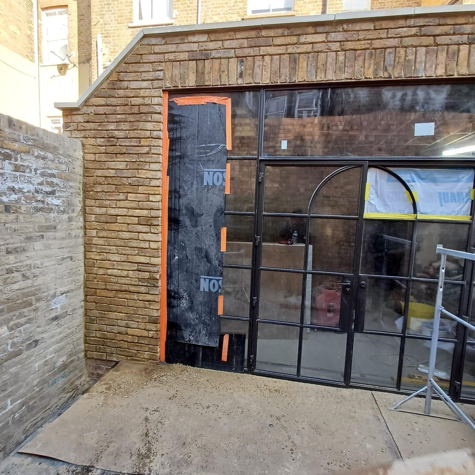 Brickwork repointing in progress with windows masked, Leytonstone