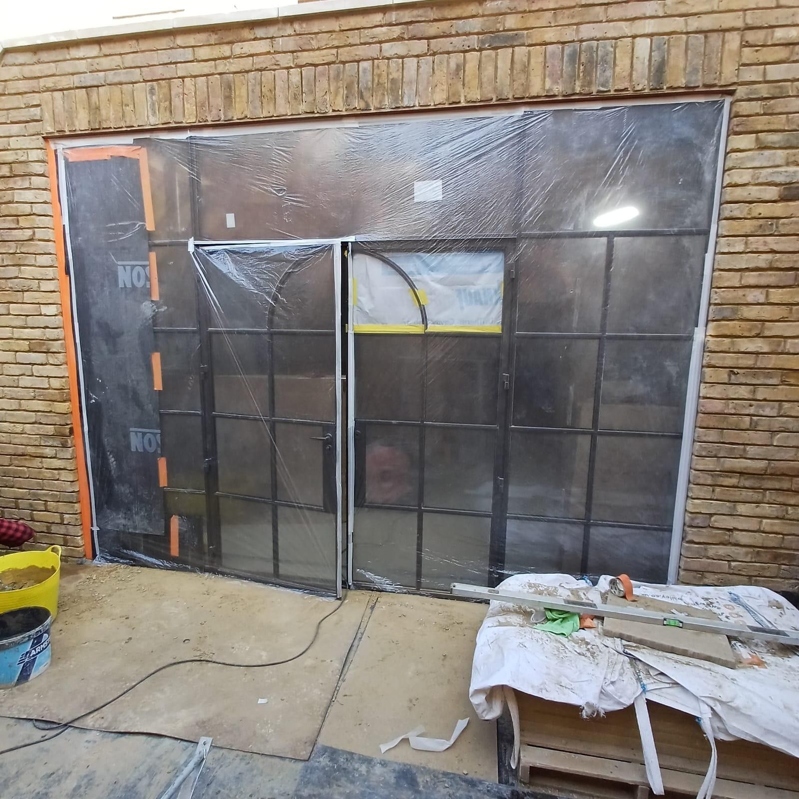 Brickwork repointing in progress with windows masked, Leytonstone
