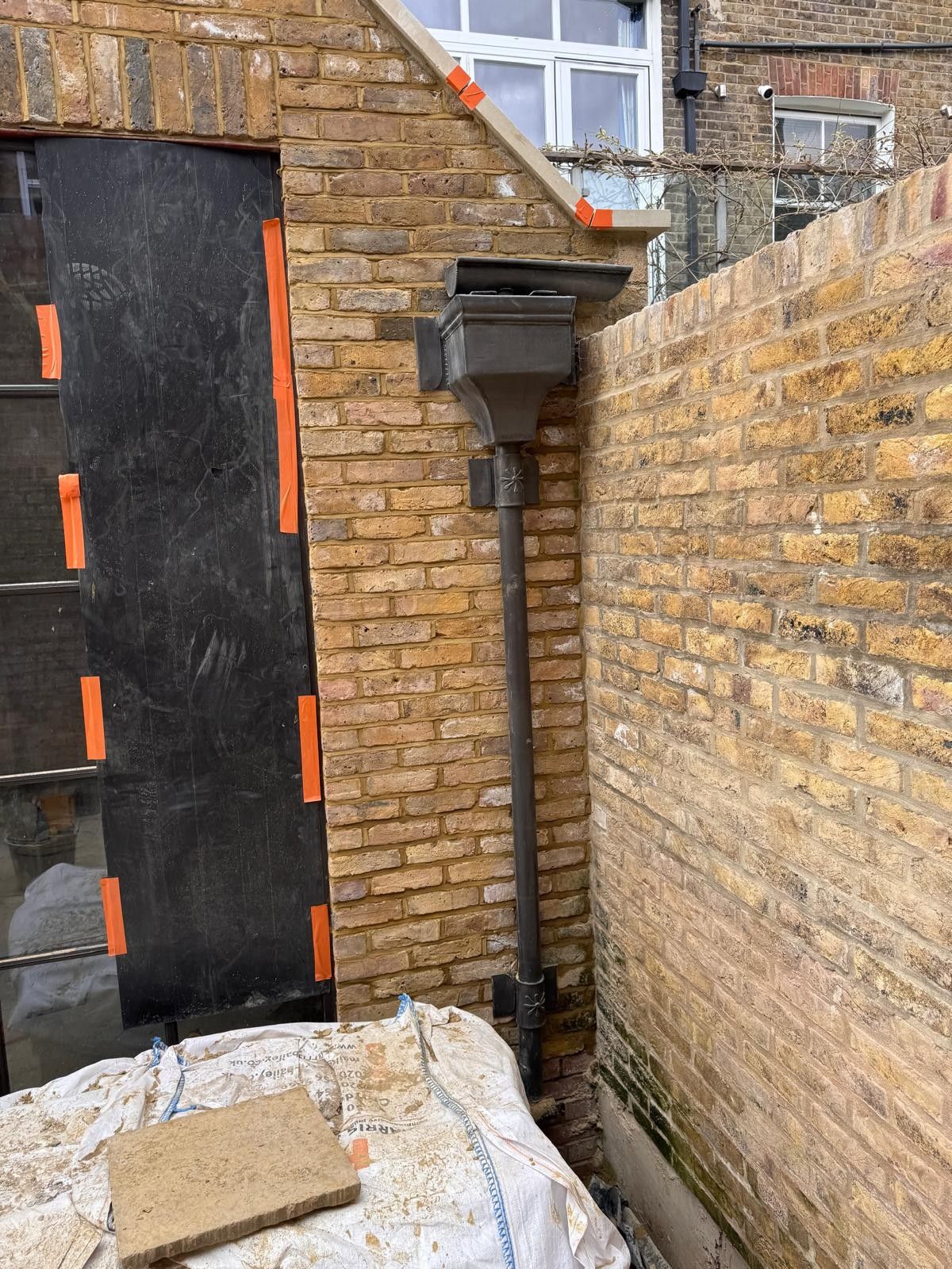 Brickwork repointing in progress with protective covers, Leytonstone
