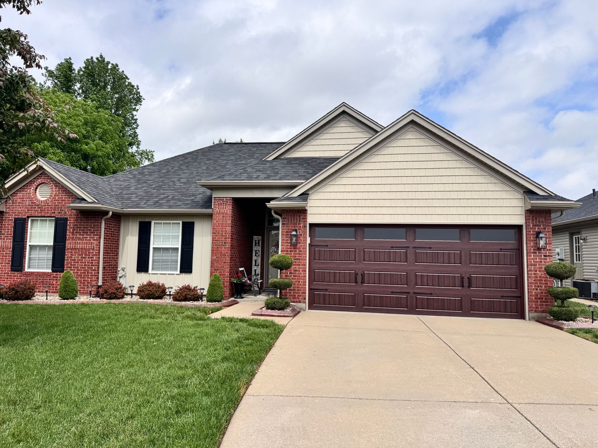 Single-story brick house with a two-car garage and a front lawn