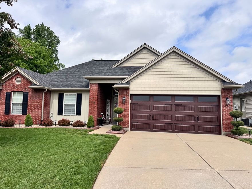 Single-story brick house with a two-car garage and a front lawn