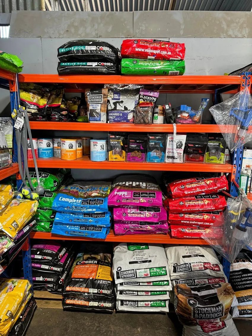 A Bunch of Bags of Dog Food Are Stacked on Top of Each — Howard Landscape and Produce Supplies in Howard, QLD