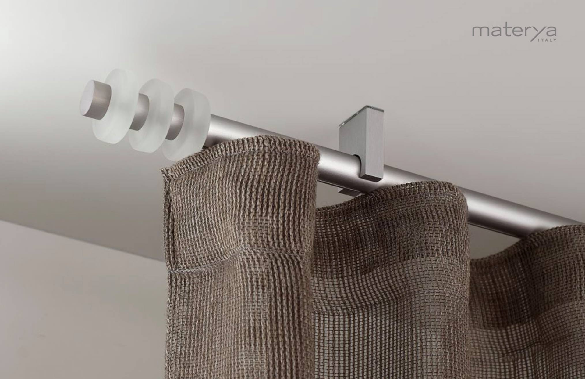 Un primo piano di una tenda con un palo di metallo appeso al soffitto