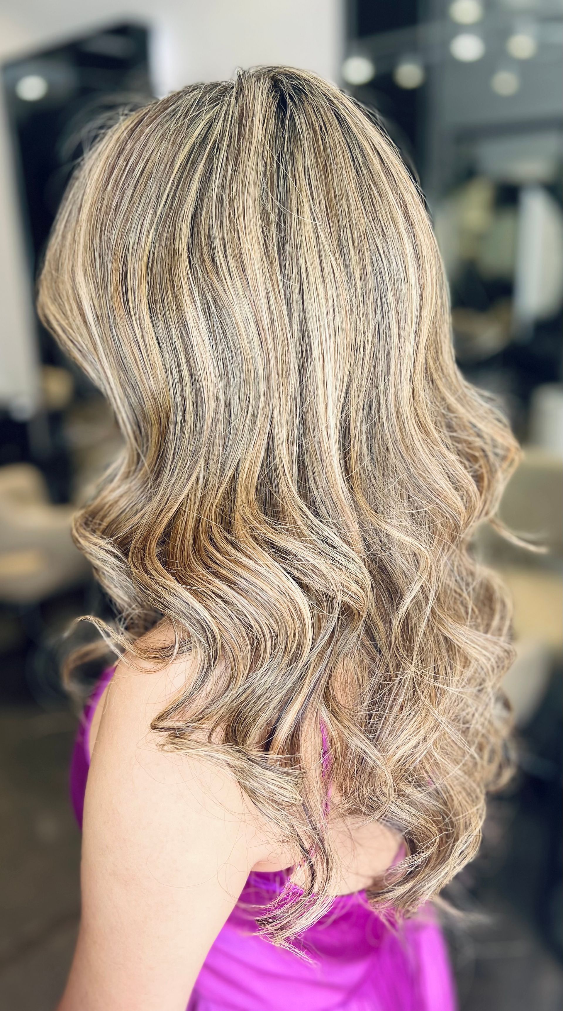 Woman With Dark Reddish-purple Wavy Hair in a Salon, Wearing a Mask and a Black Top — Studio 23 In Biggera Waters, QLD