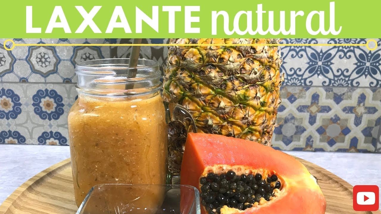 Frasco de jugo laxante natural con piña y papaya sobre un fondo de azulejos estampados.