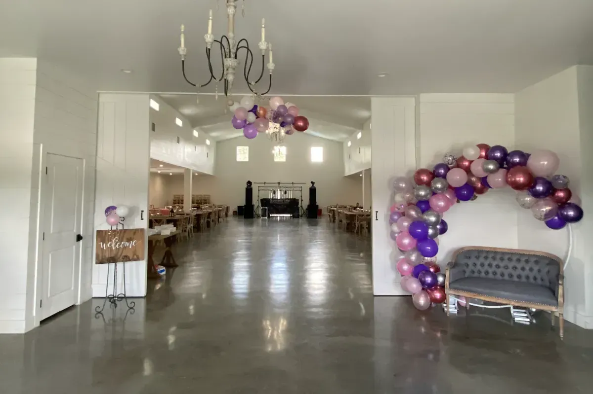 A large room with balloons hanging from the ceiling and a couch.