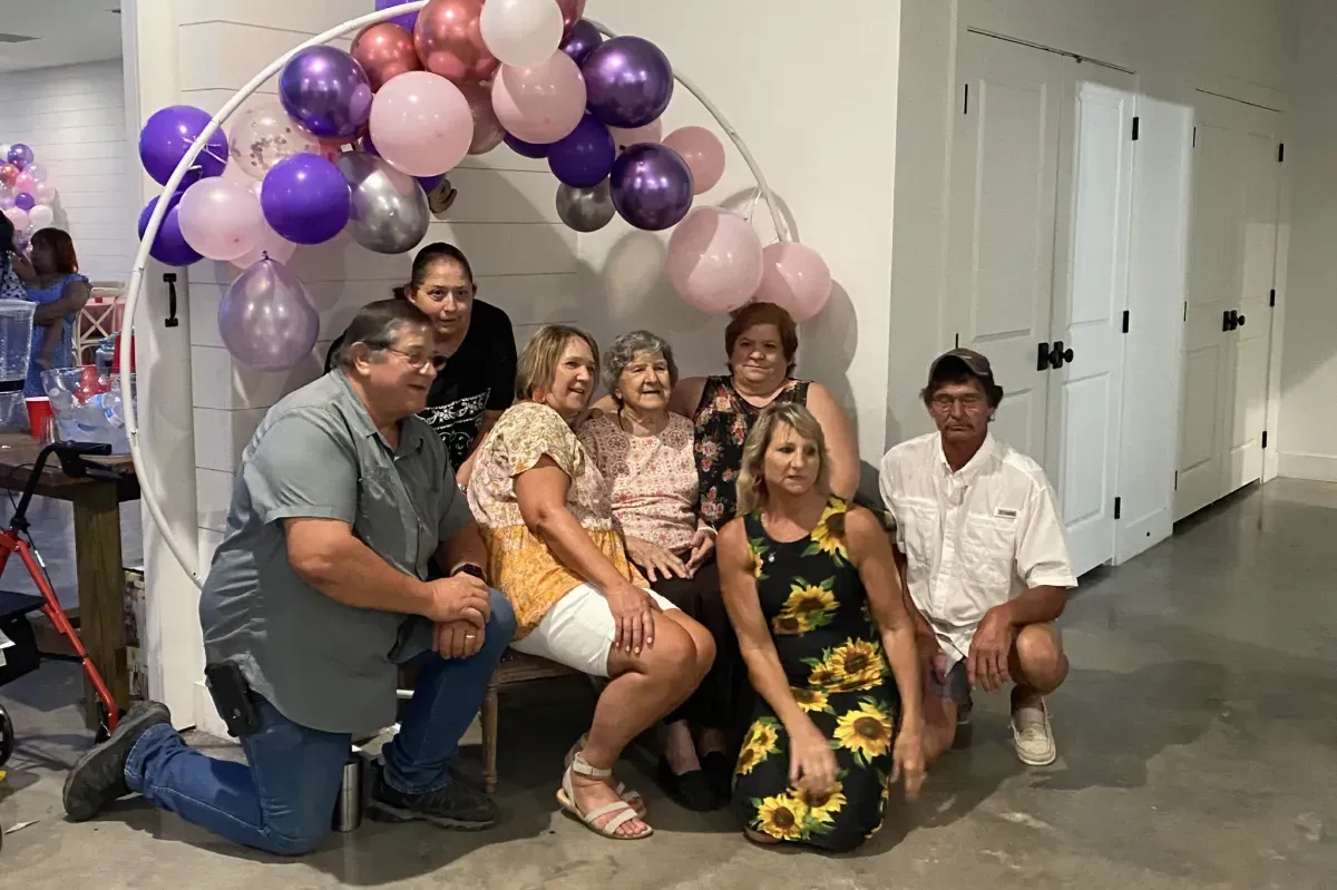 A group of people are posing for a picture in front of balloons.