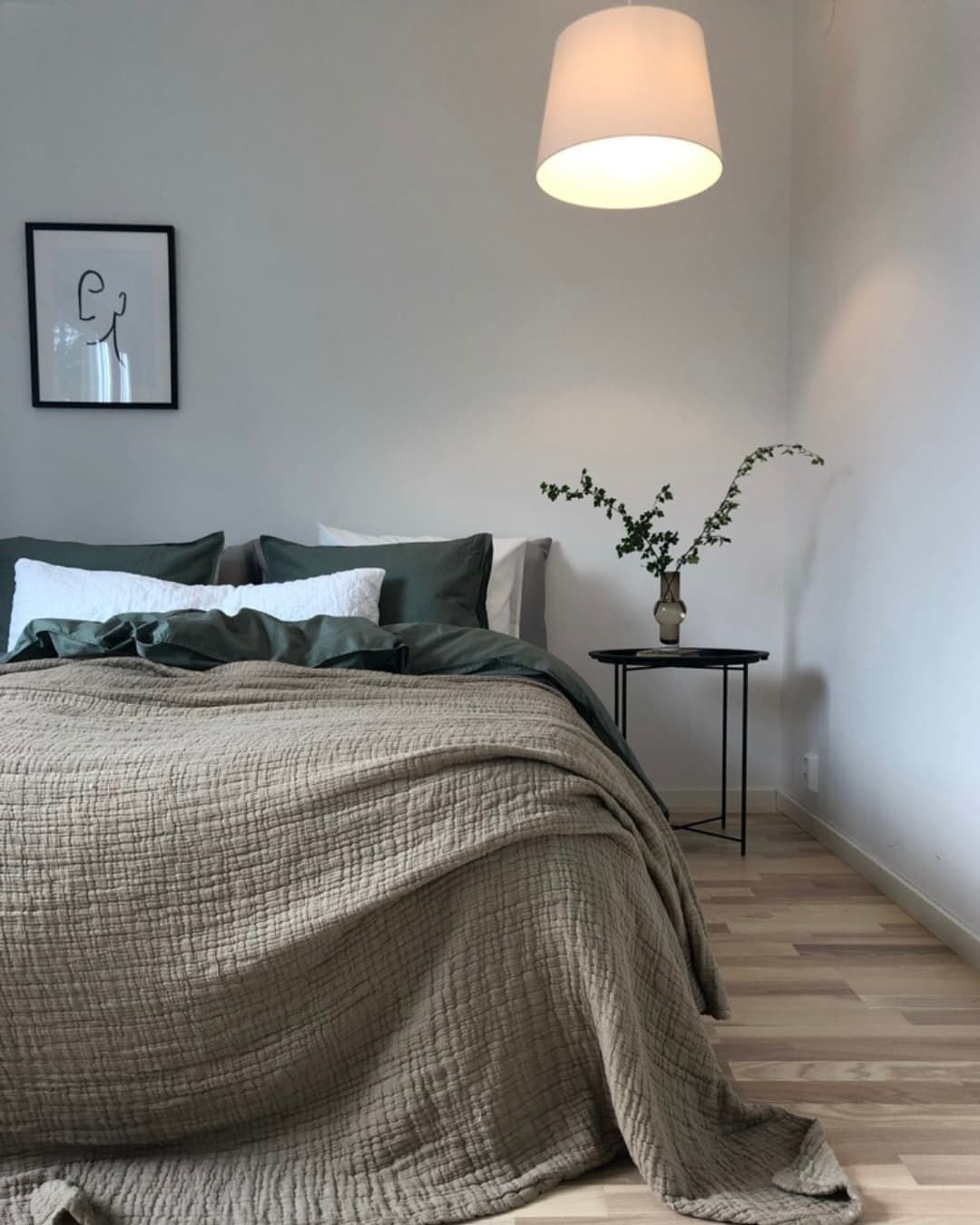 Ett sovrum med en stor säng och en lampa - hjälp med heminredning karlstad