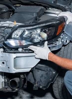 Autobody repair - headlight being replaced by a technician.