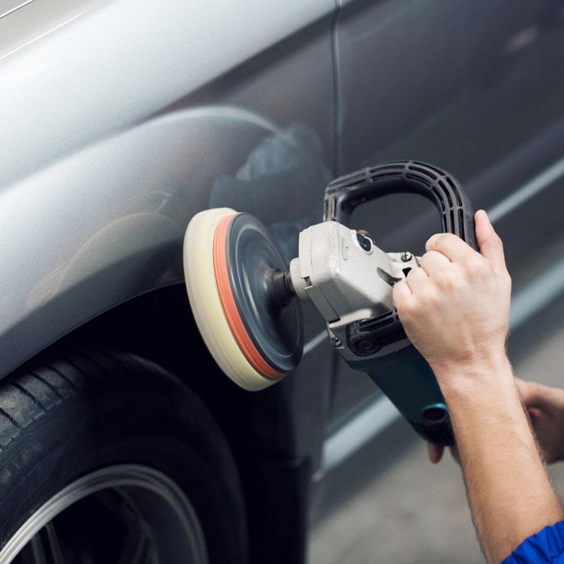 Power buffing a car after a new paint job.