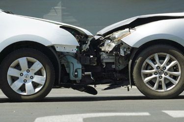 Collision repair - 2 crashed cars nose to nose.